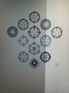 An arrangement of antique stove tops on a wall