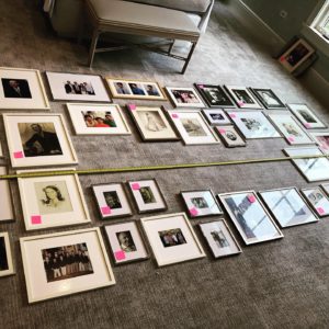 Family photos laid out on the floor before installation on the wall