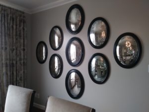A gallery of 9 oval mirrors on a dining room wall by ILevel