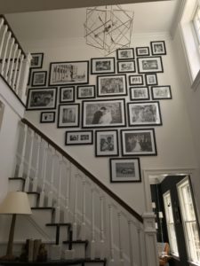 A family photo gallery wall hanging in a stairway in beautiful home
