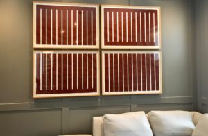 4 prints of white and red contrasting lines in wooden frames in a grid arrangement