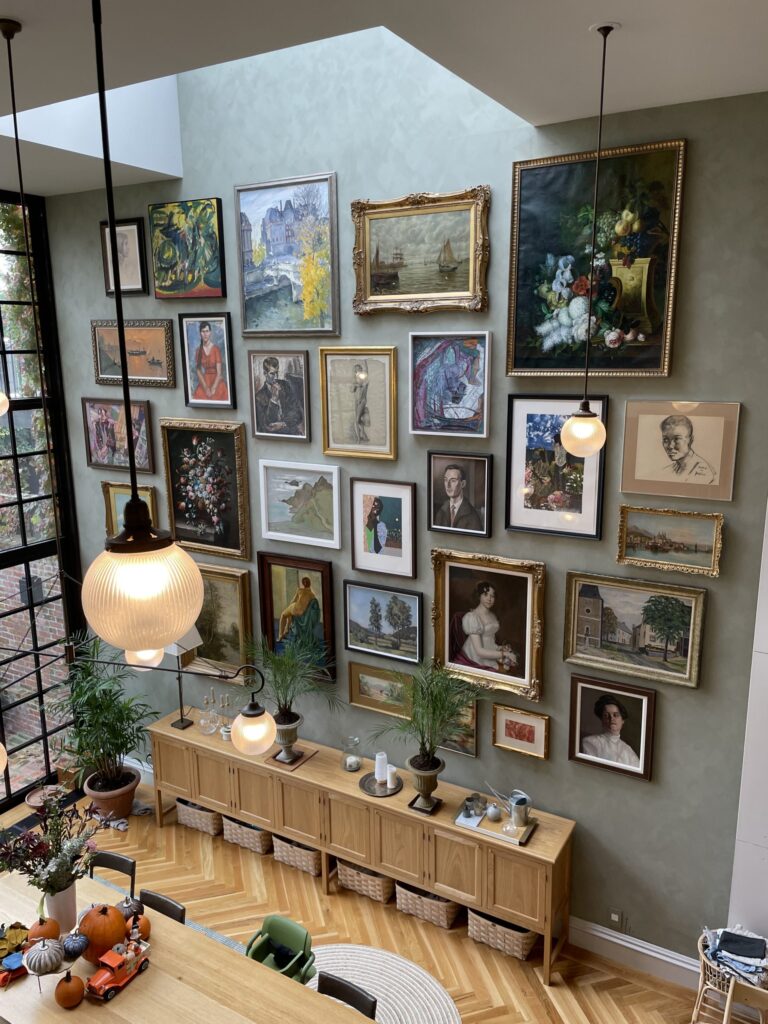 Photograph of large high wall with large collection of art on it