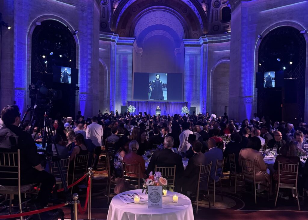 Collection of tables facing gala stage in ballroom