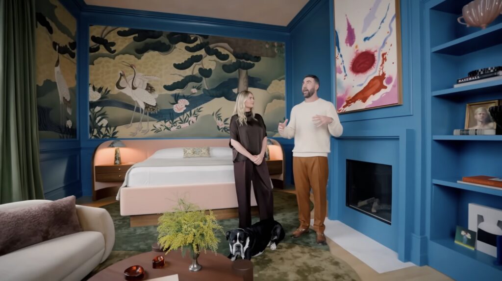 Kate Upton and Justin Verlander in the blue primary bedroom of their NYC penthouse with Japanese crane mural wallpaper and painting above fireplace, designed by John Ruggiero