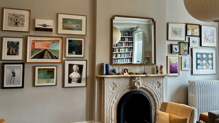 Gallery walls with mixed artwork installed on either side of a fireplace and mantel in a New York City living room by ILevel Art Installation