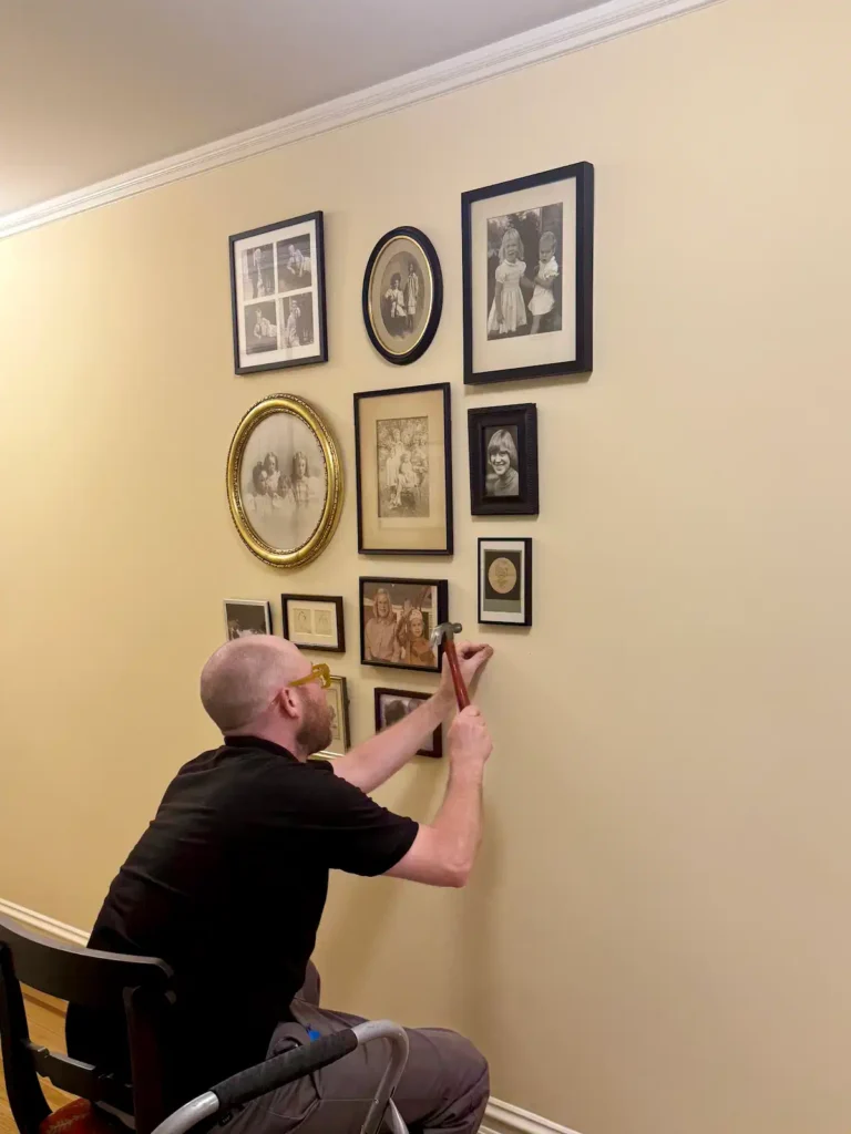 ILevel art installer hanging a family photo gallery wall in a residential home