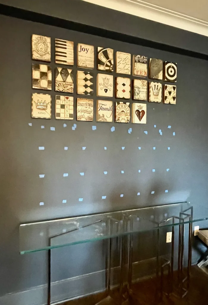 Blue tape marks on a wall showing placement layout before art installation by ILevel