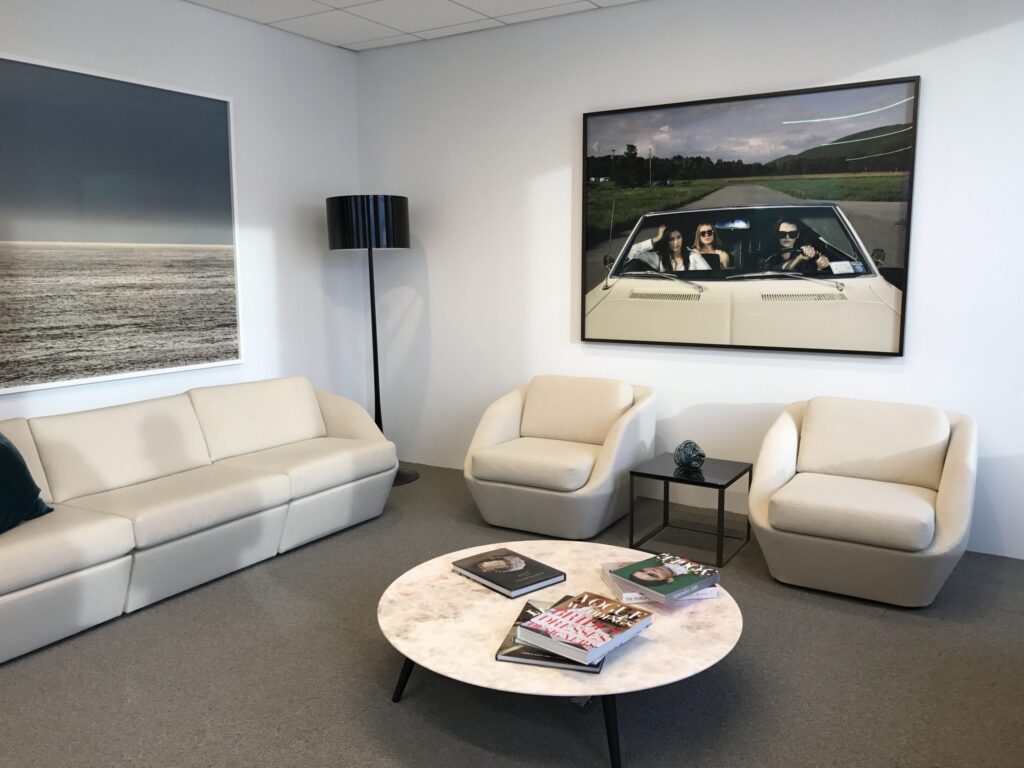 Photo of large art installed behind two white chairs in corporate office