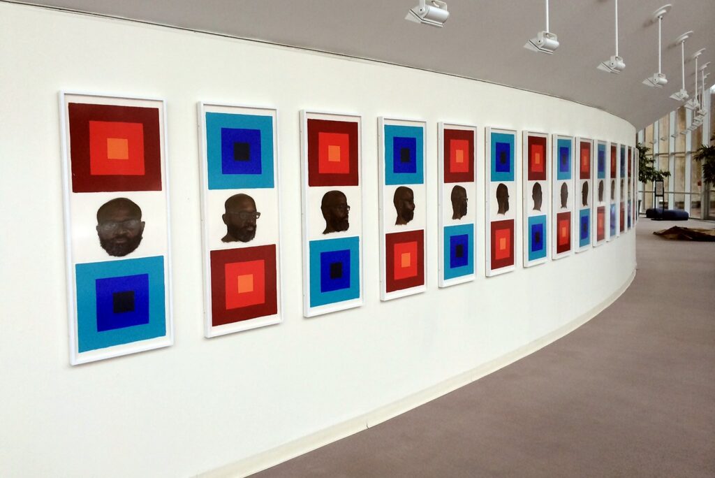 Framed prints installed in a continuous series along a curved gallery wall