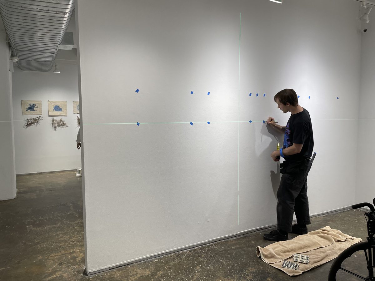 Wall layout marked with a laser line before an office art installation.