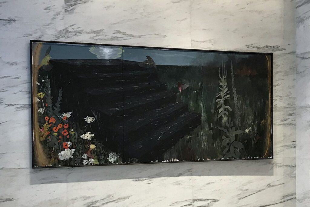 Large dark landscape painting with wildflowers installed on a white marble lobby wall