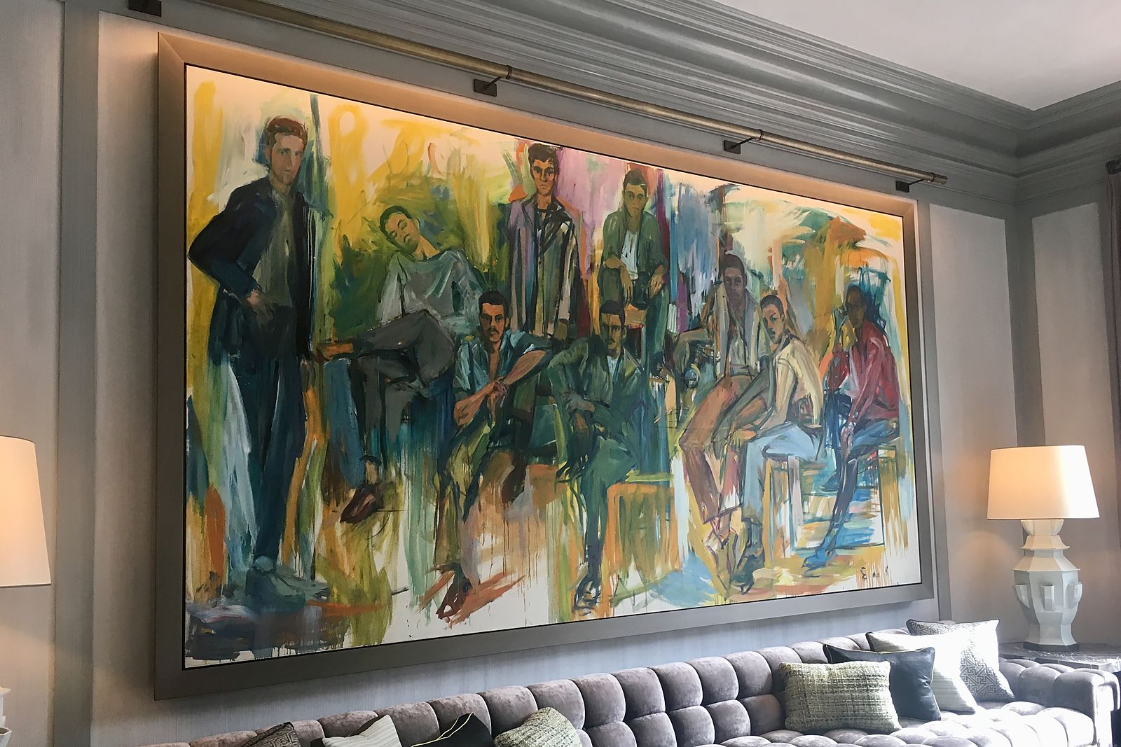 Monumental figurative painting with picture lights installed above a tufted sofa in a lounge