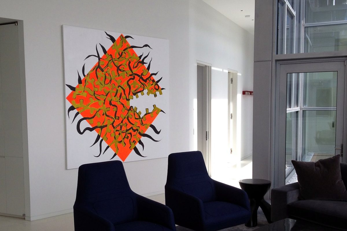 Large artwork installed above seating in a lobby.
