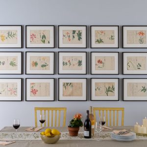 Gallery wall installation of 15 picture frames above kitchen table