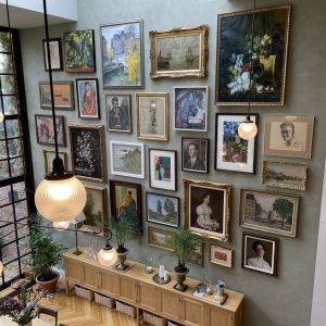 Photograph of large high wall with large collection of art on it