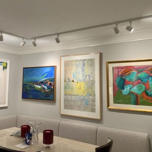collection of four very large framed pieces of art above kitchen nook, bench and table