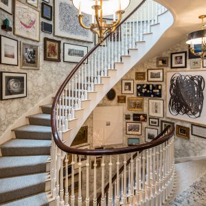 Picture of spiral staircase with large collection of framed art